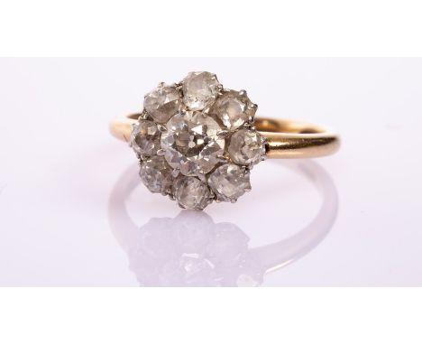 An Edwardian diamond cluster ring, the nine-stone flowerhead cluster with circular old cut central stone of approximately 0.8