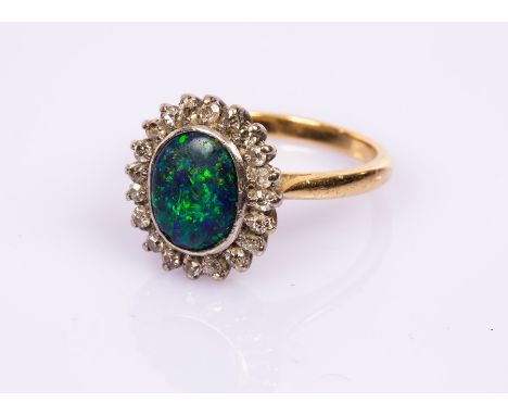 A black opal and diamond cluster ring, the oval opal to a surround of twenty diamonds, on an 18ct yellow gold shank, size P, 