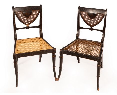 A pair of Regency ebonised single chairs with cane seats and backs and gilt painted arabesque scrolls etc, with fan shaped ba