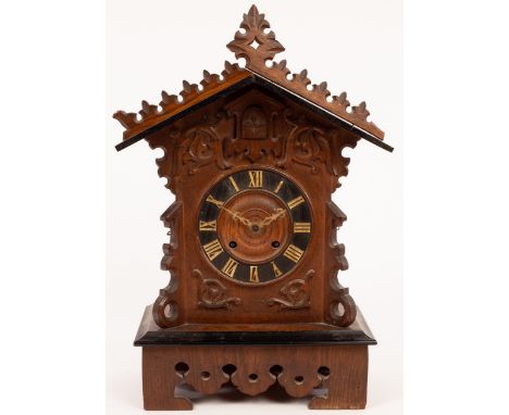 A Black Forest cuckoo clock, the case with Gothic style carving, the dial with Roman numerals and cylinder movement, 49cm hig