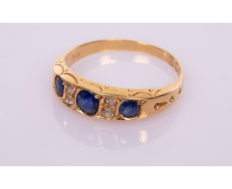 A sapphire and diamond ring in 18ct gold, the three sapphires interspersed by pairs of small diamonds, size L½ , weight appro