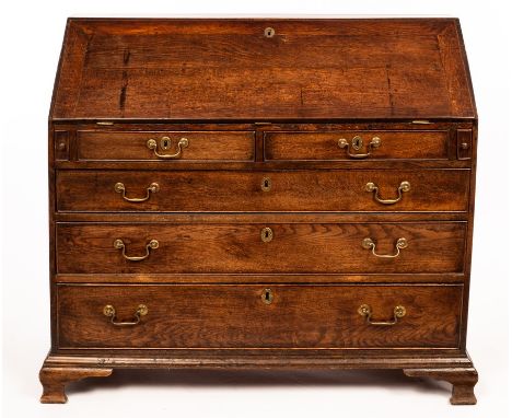 A George III oak bureau, fitted beneath the fall with three long and two short drawers beneath, on bracket feet, 105cm wide C