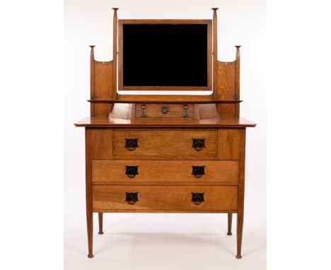 An Art Nouveau oak dressing table, retailed by Maple &amp; Co, the mirror back above a compartment enclosed by a fall flap, t