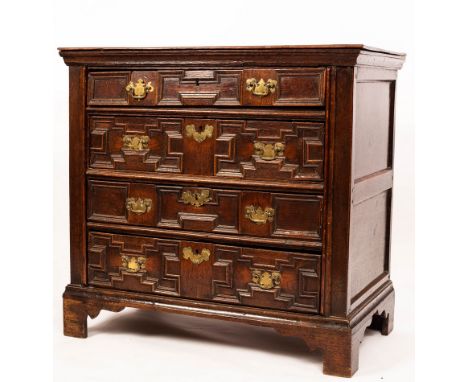 A 17th Century oak chest with plain rectangular top, fitted four drawers with geometric moulded trails, on later bracket feet