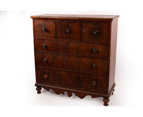 A Victorian mahogany chest of drawers with a shaped apron, fitted three short drawers over three long drawers, the turned han