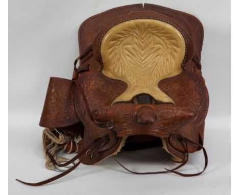 WESTERN SADDLE 
light brown leather with cream leather seat, highly tooled and with floral decoration, sheepskin lined, pomel