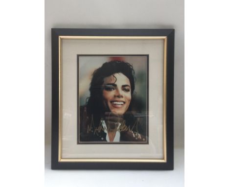 A framed and glazed signed photo of Michael Jackson, approx 35cm x 40cm. Comes with COA from a UACC registered member.