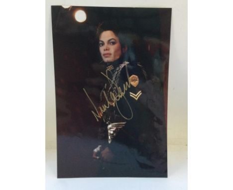A signed photo of Michael Jackson with COA. Approx 20cm x 30cm.