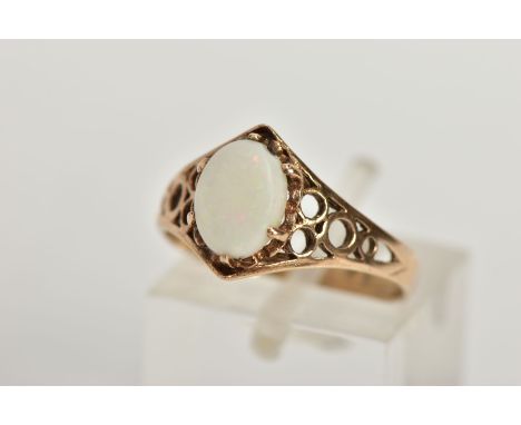 A 9CT GOLD OPAL RING, designed with an oval opal cabochon in a six claw setting, openwork detailed shoulders leading onto a p