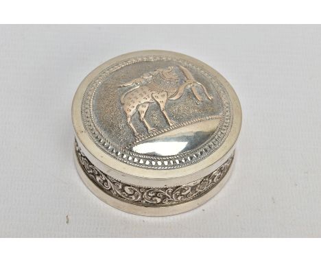 AN INDIAN WHITE METAL BOX, the circular box with scroll and floral embossed detail and fitted lid, approximate diameter 64mms