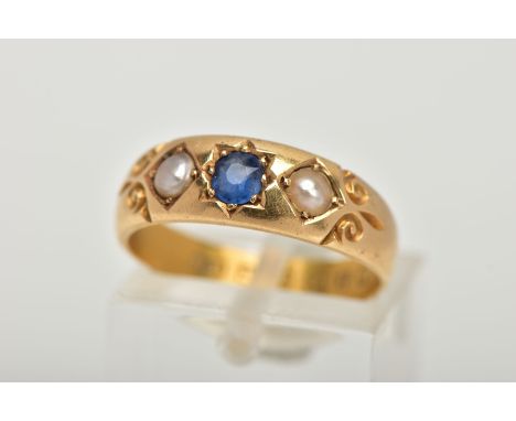 A LATE VICTORIAN 18CT GOLD RING, centring on a star set, cushion cut blue sapphire, flanked with split pearls, scroll detail 