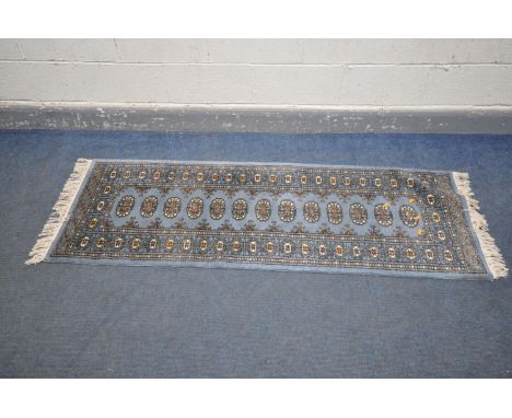 A WOOLLEN TEKKE CARPET RUNNER, with blue ground, 182cm x 66cm