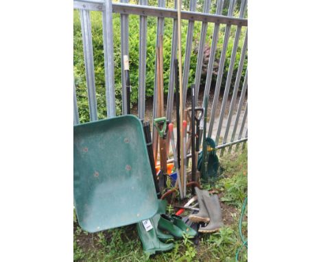 A SELECTION OF GARDEN TOOLS, to include two spades, one shovel, a rake, axe, show plough, plastic wheelbarrow, etc, along wit