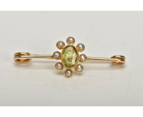 A YELLOW METAL PERIDOT AND SPLIT PEARL BAR BROOCH, the oval collet set peridot, within a split pearl cluster surround, stampe