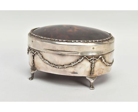 AN EARLY 20TH CENTURY SILVER AND TORTOISESHELL HINGED BOX, the oval trinket box with embossed garland and swag detail to the 