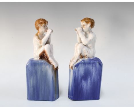 A pair of art pottery fauns on large blue bases, 25cm a/f with instruments &amp; tails broken (2)