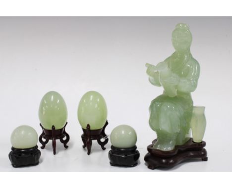 Jade figure on a wooden base together four jadeite eggs on wooden stands (5) 