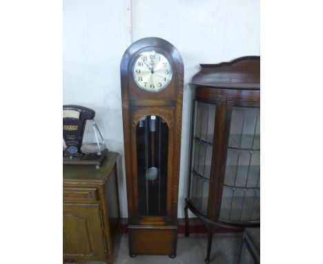 A 1930's oak triple weight longcase clock