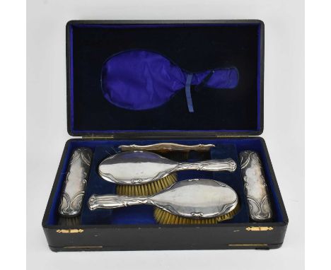 A cased Victorian hallmarked silver dressing set. The lot to include two brushes a comb and two clothes brushes. Hallmarked y