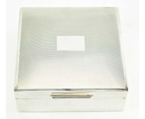 A mid century 1950 hallmarked silver cigarette box. The square shaped silver box decorated with engineered pattern to the lid
