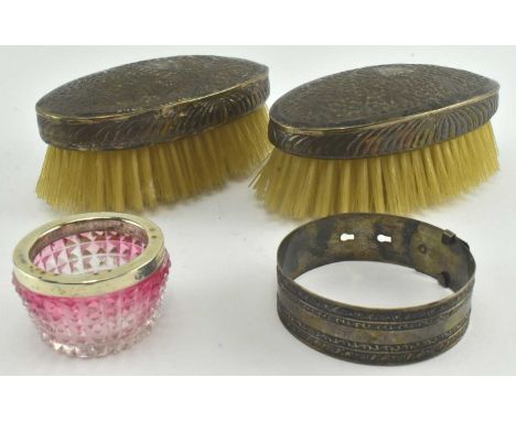 A collection of hallmarked silver pieces. The lot to include a Sterling silver marked bangle in form of a belt, a hallmarked 
