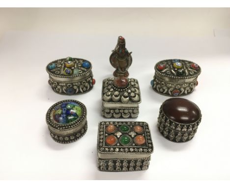 Six metal trinket boxes set with stones and millefiore glass together with a similar scent bottle (7).