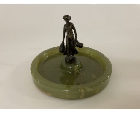 A small figure of a bronze mounted on an onyx ashtray.