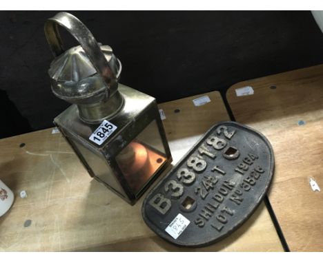 A cast iron railway sign together with brass oil lamp