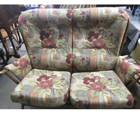 An Ercol cottage style three piece suite with floral upholstery.