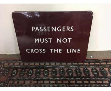 A railway enamel sign passengers must not cross the Line .