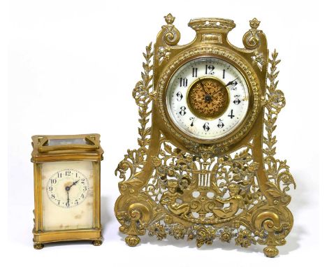 A late 19th /early 20th century brass easel back mantel clock with carved and pierced decoration of cherubs flanking a lyre b