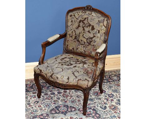 A French carved open sided elbow chair with tapestry back and seat on cabriole supports.