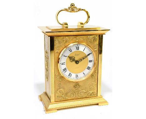 IMHOF; a contemporary gilt metal mantel clock with shaped handle and applied scrolling detail with silvered dial and Roman nu