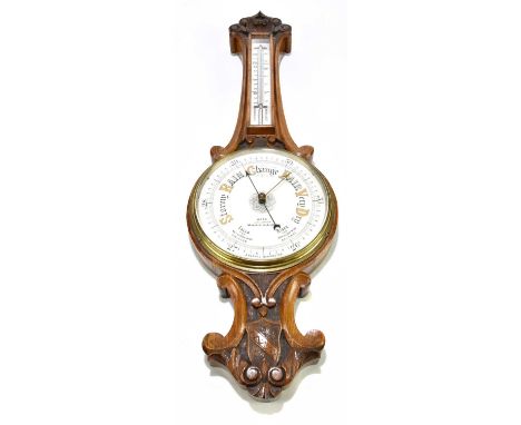 WOOD (LATE ABRAHAM) MANCHESTER &amp; LIVERPOOL; a late Victorian carved oak aneroid barometer, with thermometer, length 78cm.