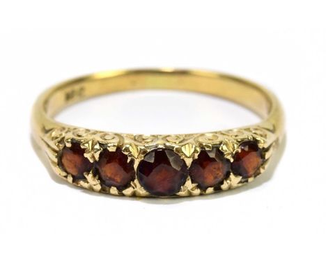 A yellow metal five stone garnet ring stamped '18c', size O, approx. 3.3g. 