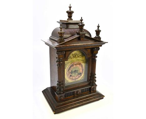 A late 19th century German mantel clock, the brass face with applied floral decoration and copper chapter ring bearing Arabic