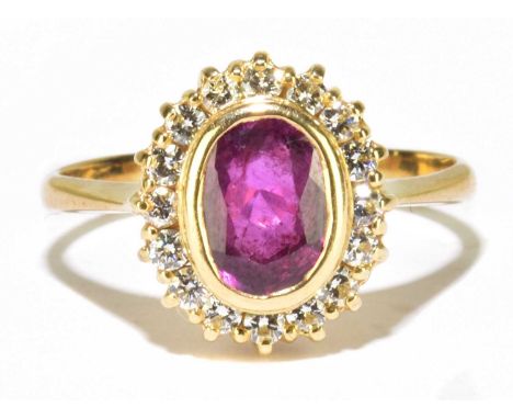 An 18ct yellow gold ruby and diamond oval ring, the rubover set ruby within a border of sixteen round brilliant cut diamonds,