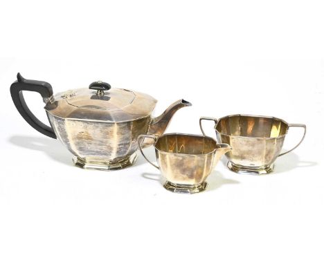 COOPER BROS &amp; SONS; a George VI hallmarked silver three piece tea service with panelled decoration, the teapot with prese