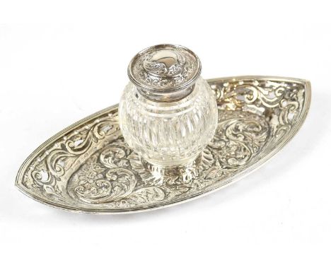 HASELER BROS; a late Victorian hallmarked silver ink stand, with ribbed glass bottle and embossed and pierced boat shaped sta