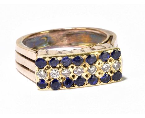 A yellow metal dress ring, set with slightly curved rectangular panel with fourteen round brilliant cut sapphires and seven s