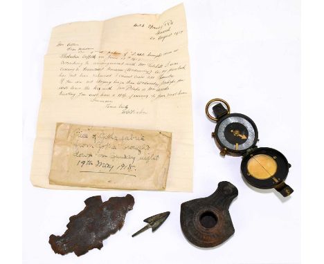 A WWI lacquered brass compass, number 36425, dated 1915, with a Roman oil lamp and an iron fragment purported to be a portion