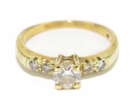 A 14ct yellow gold and diamond solitaire ring, the principal round brilliant cut stone approx. 0.20cts, with further diamonds