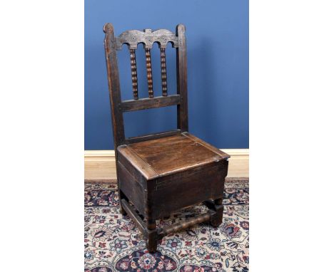 A George III provincial oak commode chair, height 103cm.