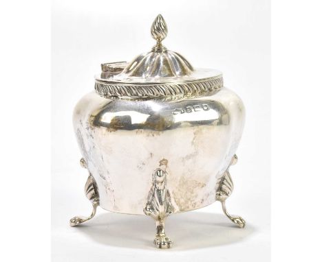 A hallmarked silver tea caddy of shaped oval form with turned finial, on four paw feet, Birmingham (marks rubbed), height 10c
