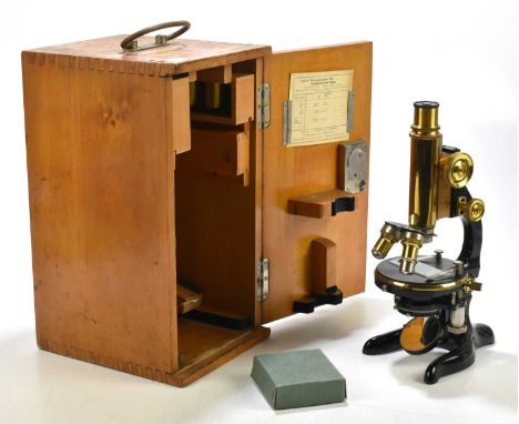 LEITZ; a cased brass and lacquered microscope with extra lenses and fitments, within a wooden case. 
