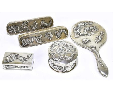 A Chinese white metal four piece dressing table set, possibly Luen Wu, comprising circular box and cover, two brushes and a h