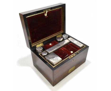 A 19th century rosewood toilet box, the leather and velvet lined compartmented interior enclosing various plate mounted toile