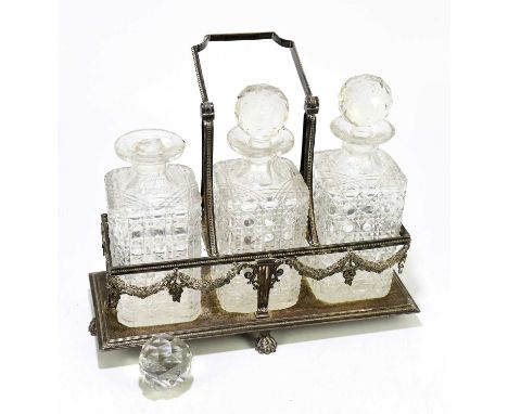 An Edwardian silver plated three bottle tantalus, of neo-Classical design, with swing handle and paw feet, height with handle