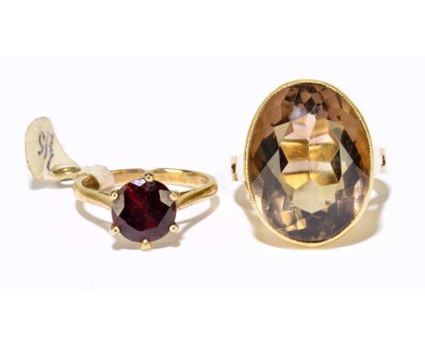 A 9ct yellow gold garnet claw set ring, size I, approx. 2.7g, and a yellow metal smoky quartz set ring, size J 1/2 (open P 1/