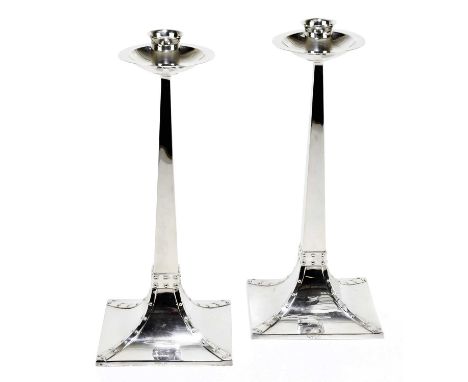 JAMES DIXON &amp; SONS; a pair of Edward VII hallmarked silver Arts and Crafts candlesticks with circular drip trays on taper